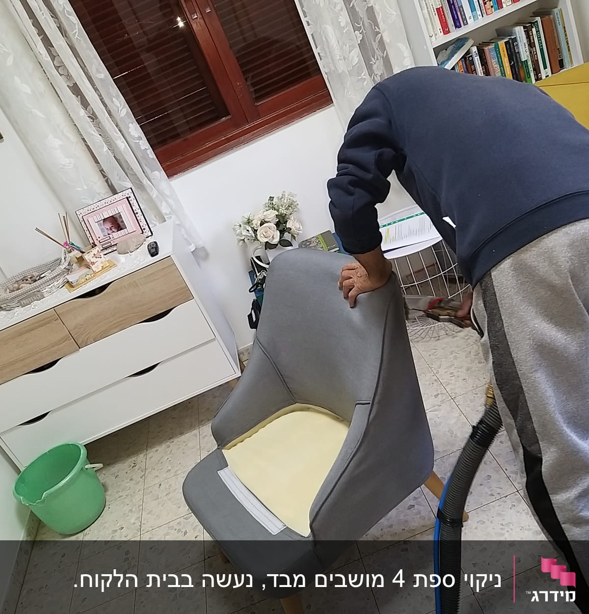 אדם מנקה כורסה עם שואב אבק